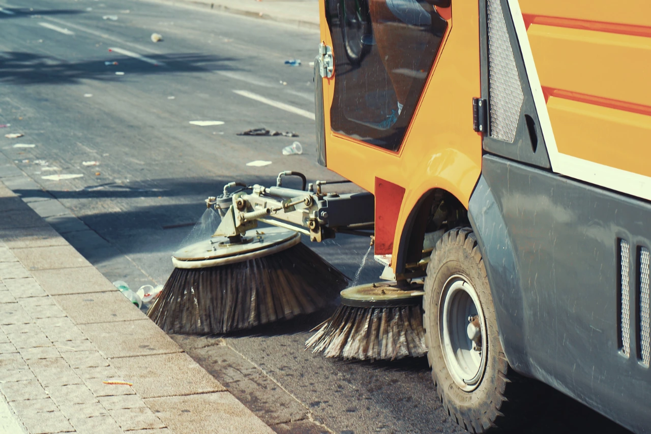 Straßenreinigung – moderne Kehrmaschine reinigt verschmutzte Straßen effizient